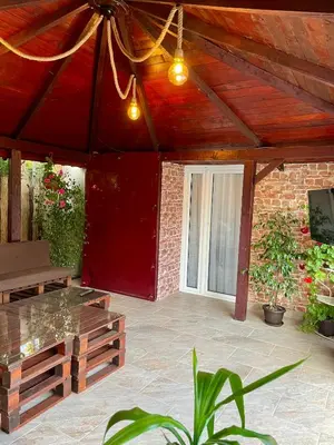 a patio with a table and a brick wall at Airport Apartments Alexandra in Surčin