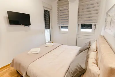 a white room with a couch and a television at Rajski Kutak in Arandjelovac