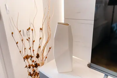 a white vase sitting on a table next to a tv at Rajski Kutak in Arandjelovac