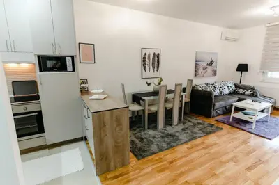 a kitchen and living room with a couch and a table at Rajski Kutak in Arandjelovac