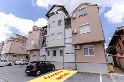 a car parked in a parking lot in front of a building at RoofTop in Arandjelovac