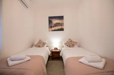two twin beds in a room with a lamp at Gardoš rooms in Zemun
