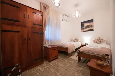 a room with two beds and a dresser and a bedroom at Gardoš rooms in Zemun