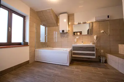 a bathroom with a tub and a sink and a mirror at Gardoš rooms in Zemun