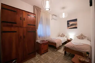 a room with two beds and a dresser in a room at Gardoš rooms in Zemun
