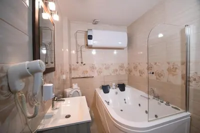 a bathroom with a tub and a sink and a shower at Gardoš rooms in Zemun