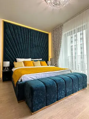 a bedroom with a large bed with a blue headboard at Beldorado Apartments - Belgrade Waterfront Royal Luxury Studio in Belgrade