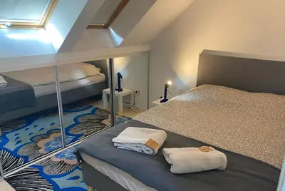 a attic bedroom with two beds and a window at Fellini Apartment in Belgrade