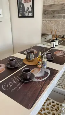 a table with cups and plates on top of a counter at Fellini Apartment in Belgrade
