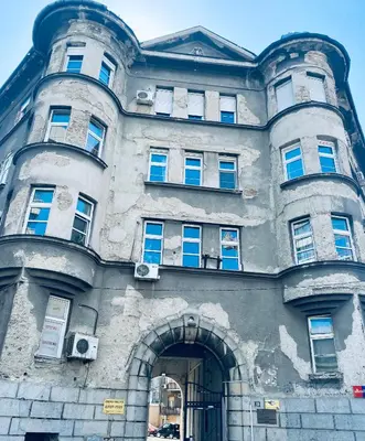 a large stone building with an arch entrance at Fellini Apartment in Belgrade