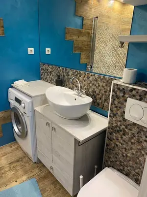 a bathroom with a sink and a washing machine at Fellini Apartment in Belgrade