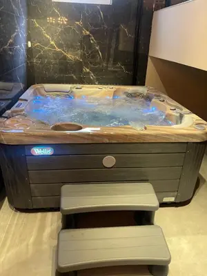 a jacuzzi tub sitting in a room with a chair at Mystique Spa Apartment in Belgrade