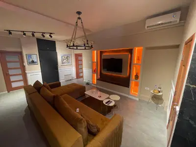 a living room with a brown couch and a tv at Mystique Spa Apartment in Belgrade