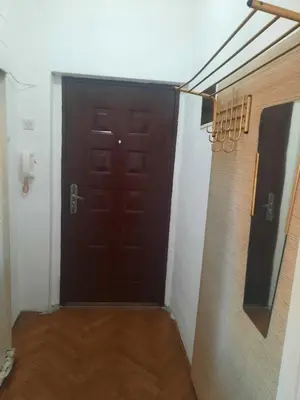 a brown door in a room with a wooden floor at Nena Apartman in Belgrade