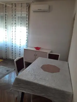 a room with a table and a dresser and a desk at Nena Apartman in Belgrade