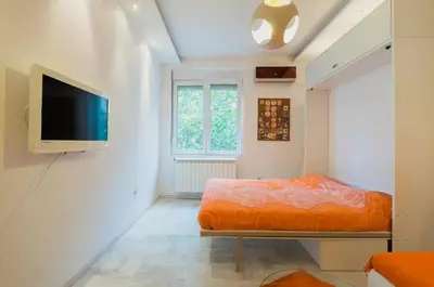 a bedroom with a bed and a flat screen tv at Porto Studio in Belgrade