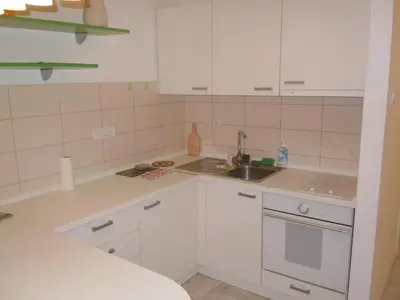 a small kitchen with white cabinets and a sink at Porto Studio in Belgrade