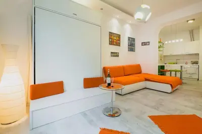 a living room with an orange couch and a table at Porto Studio in Belgrade