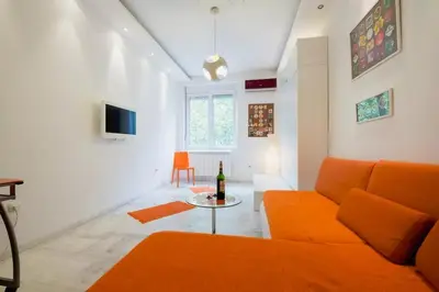 a living room with an orange couch and a table at Porto Studio in Belgrade