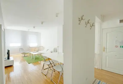 a white living room with a table and chairs at Miu Arena Apartment in Belgrade