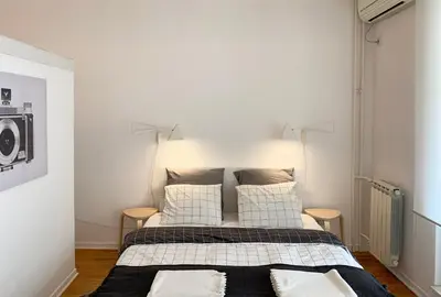 a bedroom with a bed with two lamps on it at Miu Arena Apartment in Belgrade