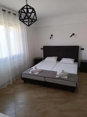 a bedroom with a bed and a chandelier at Apartman Avala Beograd in Beli Potok