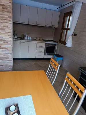 a kitchen with a wooden table and two chairs at Apartman Avala Beograd in Beli Potok