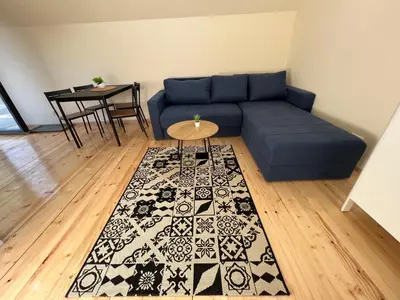 a living room with a blue couch and a table at Planinske Kuće Grocka in Grocka