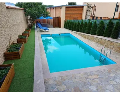 a swimming pool in a backyard with green grass at Planinske Kuće Grocka in Grocka