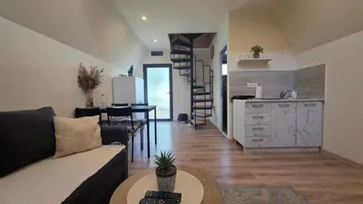 a living room with a couch and a table and a kitchen at Planinske Kuće Grocka in Grocka