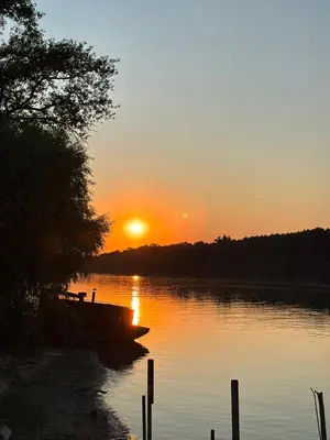 a boat sitting on the water at sunset at Kuca na Dunavu in Belgrade
