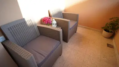 two chairs and a table with flowers in a room at President 034 Royal Spa in Arandjelovac