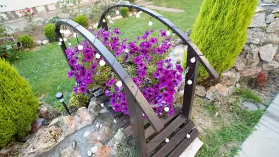 a bench filled with purple flowers in a garden at President 034 Royal Spa in Arandjelovac