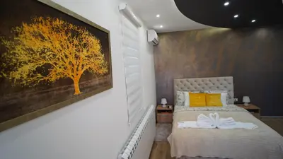 a bedroom with a tree painting on the wall at President 034 Royal Spa in Arandjelovac