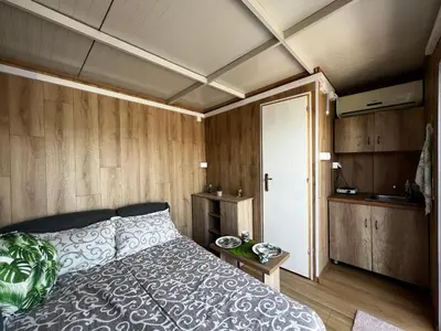 a bedroom with a bed and wooden walls at Splav na reci Savi in Ostružnica
