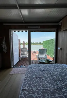 a bedroom with a bed and a view of the water at Splav na reci Savi in Ostružnica