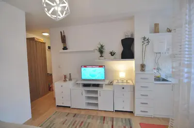 a living room with a tv on a white cabinet at Charming studio near downtown in Belgrade