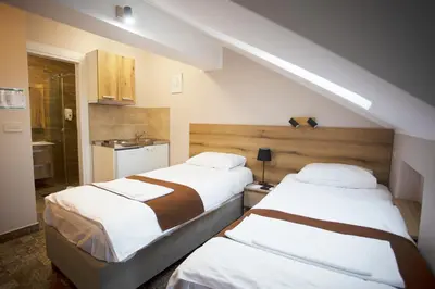 two beds in a small room with a kitchen at Soul River e cucina in Pančevo