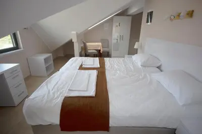 a bedroom with a large white bed with a desk at Soul River e cucina in Pančevo