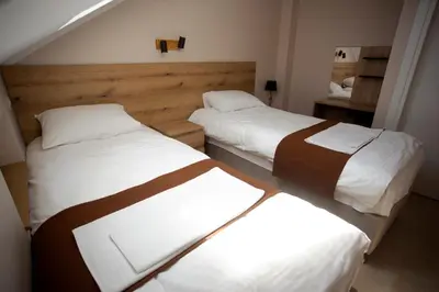 two beds in a hotel room with white and brown sheets at Soul River e cucina in Pančevo