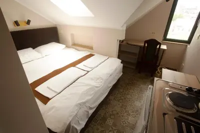 a hotel room with a large white bed and a desk at Soul River e cucina in Pančevo