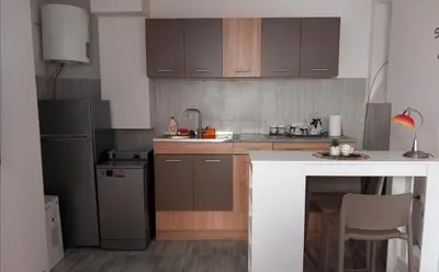 a kitchen with brown cabinets and a white counter top at Studio Neimar in Vračar (historical)