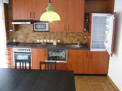 a kitchen with wooden cabinets and a sink and a refrigerator at Apartment Deligradska in Belgrade