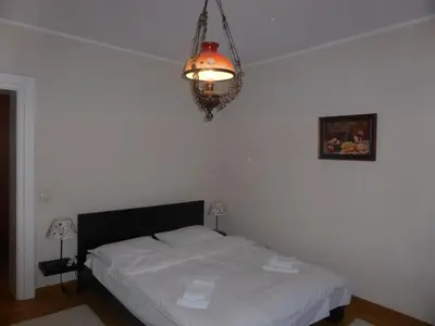 a bedroom with a bed and a chandelier at Apartment Deligradska in Belgrade