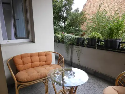 a balcony with a chair and a table and a window at Apartment Deligradska in Belgrade