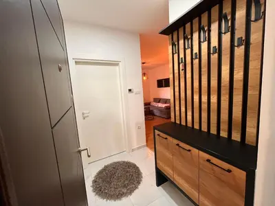a room with a closet and a door with a rug at Apartman Maša in Ruma