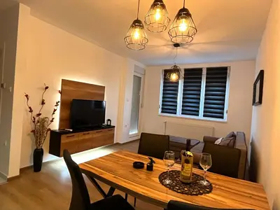a living room with a wooden table with wine glasses at Apartman Maša in Ruma