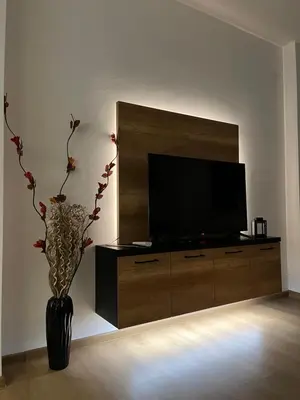 a large entertainment center with a flat screen tv in a living room at Apartman Maša in Ruma