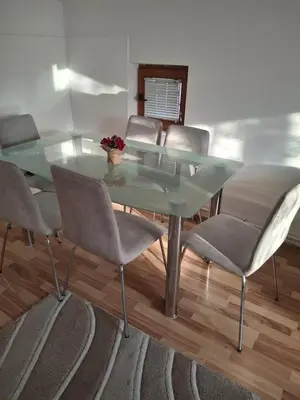 a dining room with a glass table and chairs at Jasna in Zemun