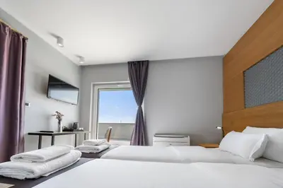 two beds in a room with a window at Prince Rooftop in Belgrade